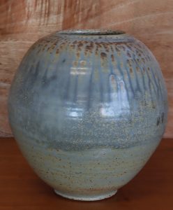 A large blue vase with carvings made by David Collins
