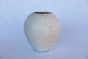 A large white vase with carvings made by David Collins