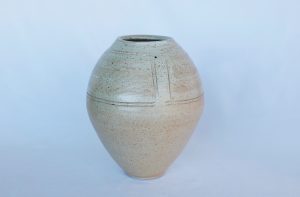 A large white vase with carvings made by David Collins