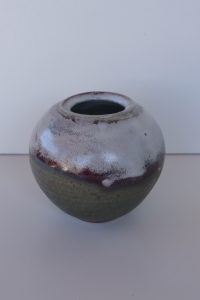 A white and brown vase made by David Collins