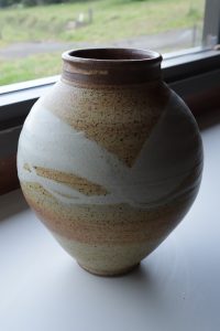 A large brown vase with white glaze made by David Collins