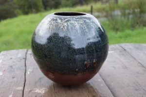 A black round vase made by David Collins