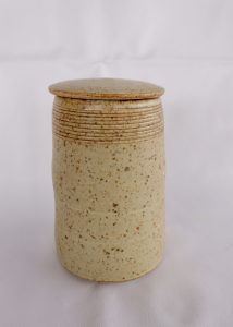 A white Tea Caddy with carved lines created by David Collins